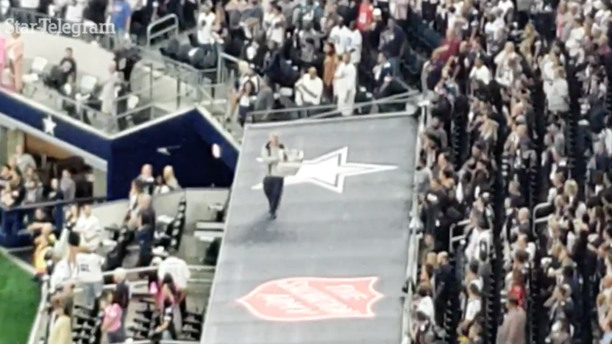 A protester held up a sign during the national anthem. (via Star-Telegram screenshot)