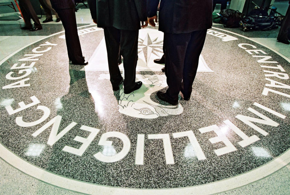 CIA emblem on floor with people's lower halves visible around it