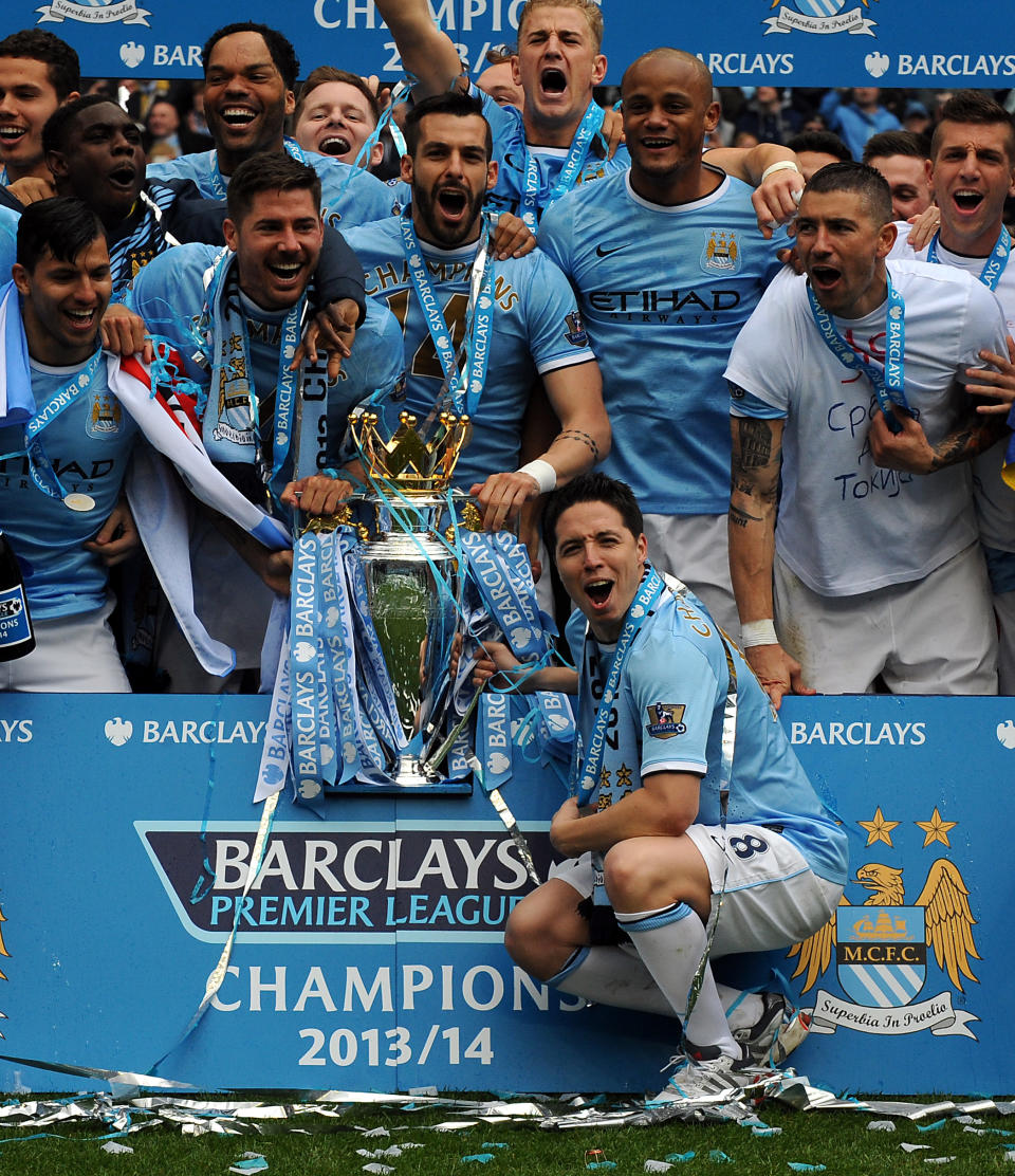 Manchester City's Samir Nasri, front, holds the cup and celebrates with team mates after being crowned Champions after the English Premier League soccer match between Manchester City and West Ham United at the Etihad Stadium, Manchester, England, Sunday, May 11, 2014. (AP Photo/Rui Vieira)