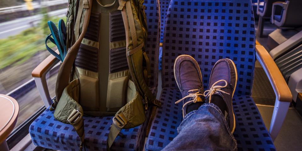 A train passenger with their feet up on a seat.