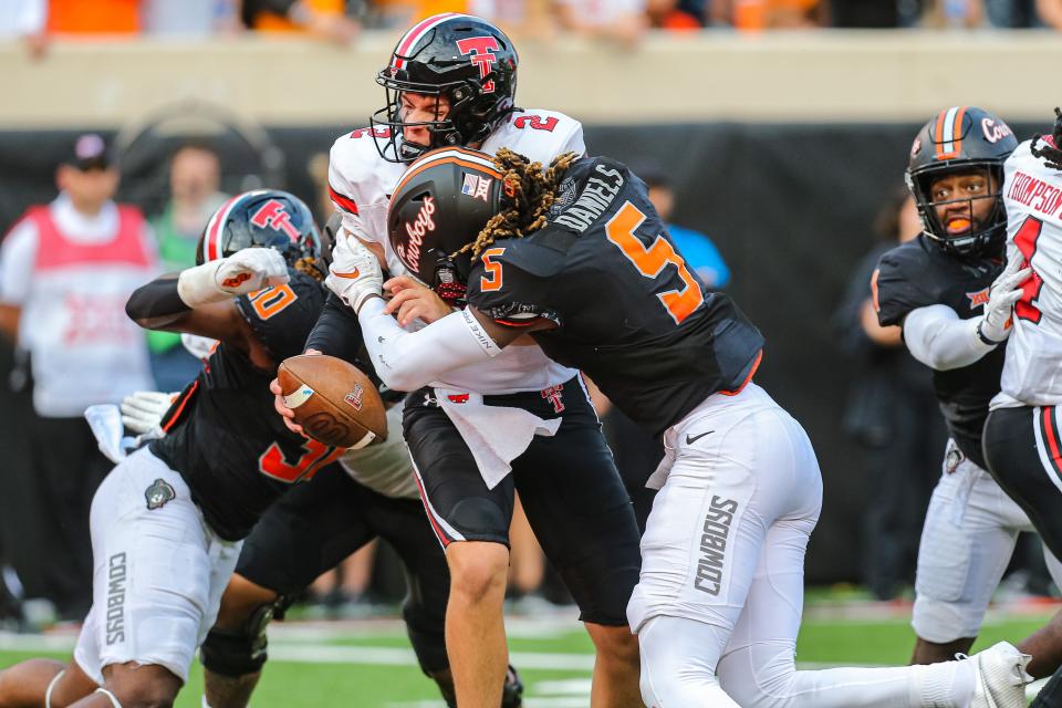 Texas Tech's Behren Morton (2) is taken down by Oklahoma State's Kendal Daniels (5) in the fourth quarter during a college football game between the Oklahoma State Cowboys and the Texas Tech Red Raiders at Boone Pickens Stadium in Stillwater, Okla., Saturday, Oct. 8, 2022. Daniels was ejected for targeting. OSU won 41-31.