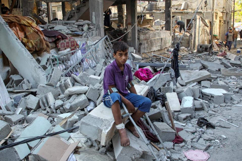 A wounded Palestinian sits on debris at the site of an Israeli strike on a house, amid the ongoing conflict between Israel and the Palestinian Islamist group Hamas, in Rafah, in the southern Gaza Strip May 9, 2024.