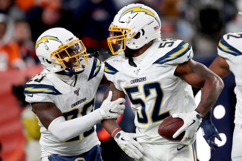 Denzel Perryman (52) of the Chargers celebrates with Desmond King II after making an interception.