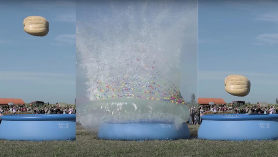 A giant pumpkin being dropped into a pool with a splash