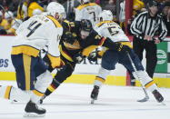 Vancouver Canucks center Zack MacEwen (71) fights to get past Nashville Predators defensemen Mattias Ekholm (14) and Dante Fabbro (57) during the second period of an NHL hockey game, in Vancouver, British Columbia, Monday, Feb. 10, 2020. (Jonathan Hayward/The Canadian Press via AP)