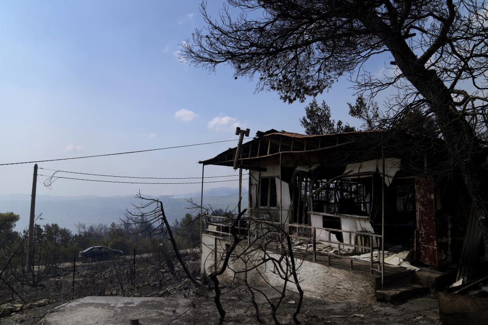 A burnt house during a wildfire in Thea area some 60 kilometers (37 miles) northwest of Athens, Greece, Thursday, Aug. 19, 2021. A major wildfire northwest of the Greek capital devoured large tracts of pine forest for a third day and threatened a large village as hundreds of firefighters, assisted by water-dropping planes and helicopters, battled the flames Wednesday. (AP Photo/Thanassis Stavrakis)