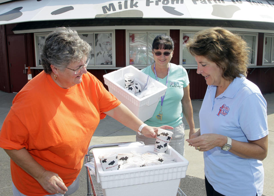 Michele Plumber, left, passes out milk shakes from the Dairy Bar to Indiana State Fair Executive Director Cindy Hoye, right, and Sandy Campbell as Hoye toured the Indiana State Fair Grounds in Indianapolis, Wednesday, July 25, 2012. Hoye is at the center of a deadly stage collapse last year says she is haunted by the tragedy but determined to help the fair move forward as it prepares for its Aug. 3 opening. (AP Photo/Michael Conroy)