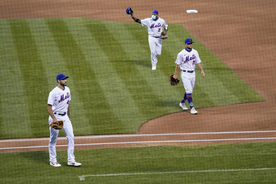 New York Mets left fielder Dominic Smith (2) tips his hat to the Miami Marlins as both teams walk off the field before a scheduled baseball game Thursday, Aug. 27, 2020, in New York. Players jointly walked off the field after a moment of silence, draping a Black Lives Matter T-shirt across home plate as they chose not to play. (AP Photo/John Minchillo)