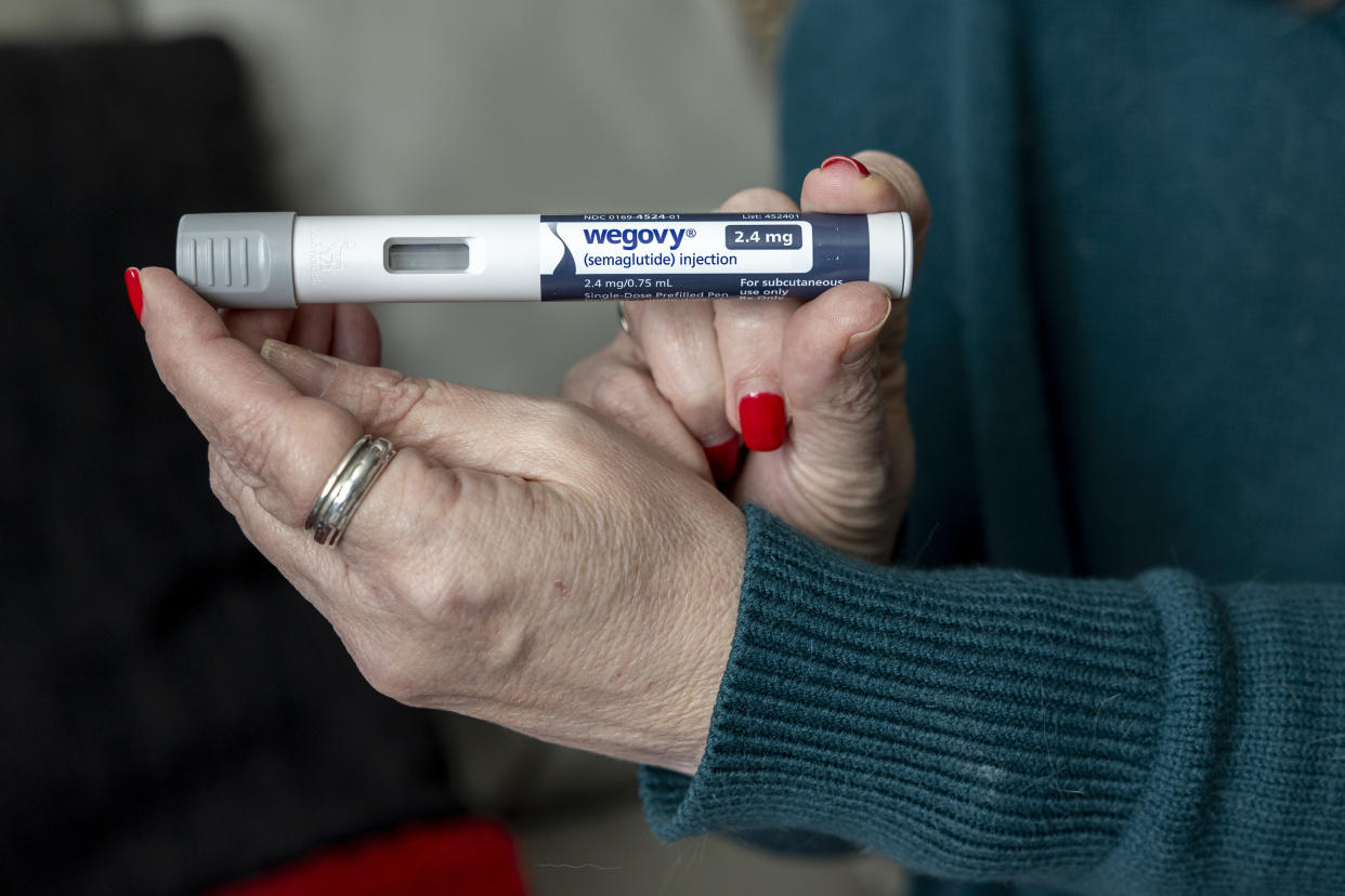 FILE - Donna Cooper holds up a dosage of Wegovy, a drug used for weight loss, at her home in Front Royal, Va., on Friday, March 1, 2024. 