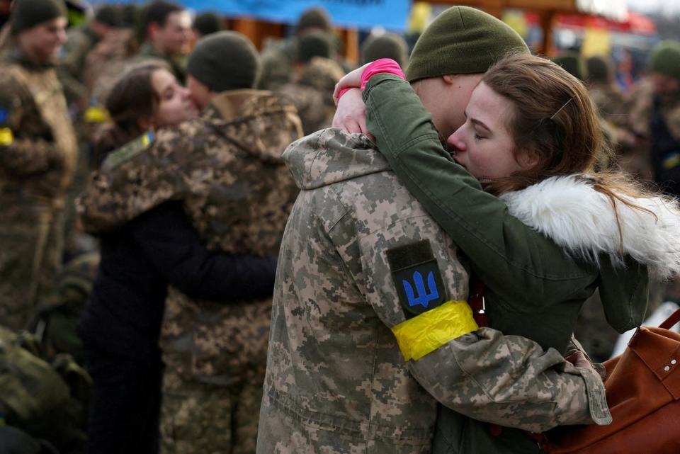 Olga hugs her boyfriend Vlodomyr as they say goodbye prior to his deployment closer to the front line at the train station in Lviv, Ukraine (Reuters)