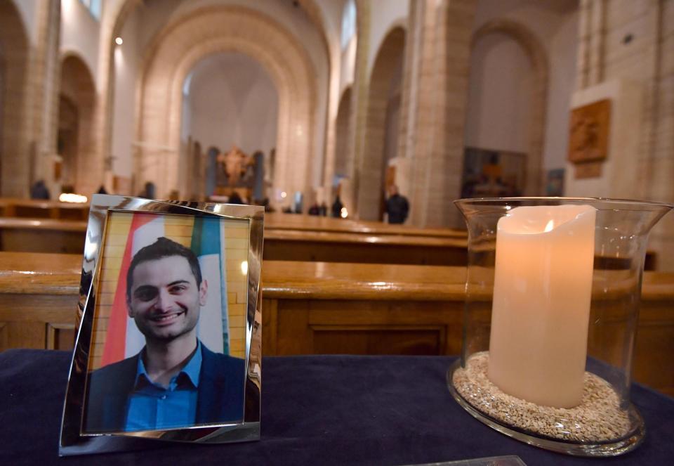 A portrait of Antonio Megalizzi, the Italian reporter killed during a terrorist attack in Strasbourg, is placed next to a candle at the church 'Cristo Re' in Trento, Northern Italy, Wednesday, Dec. 19 2018. Megalizzi and four other people died and several others were injured in a terror attack on Dec. 11 at a Christmas Market in Strasbourg, France. (Daniel Dal Zennaro/ANSA via AP)