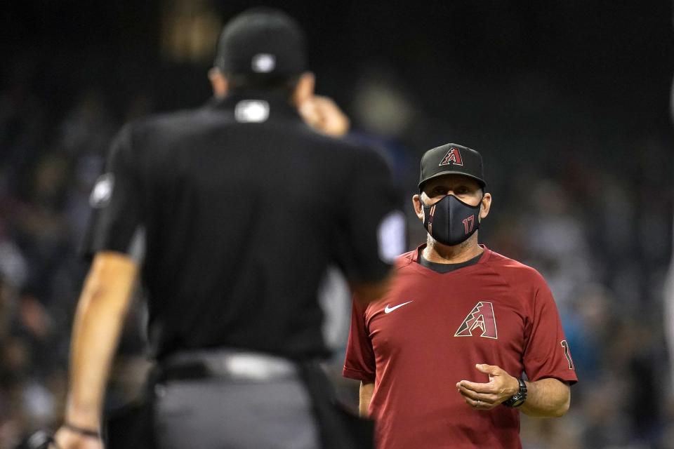 Arizona Diamondbacks manager Torey Lovullo, right, argues with umpire David Rackley during the third inning of a baseball game against the Oakland Athletics Monday, April 12, 2021, in Phoenix. (AP Photo/Ross D. Franklin)