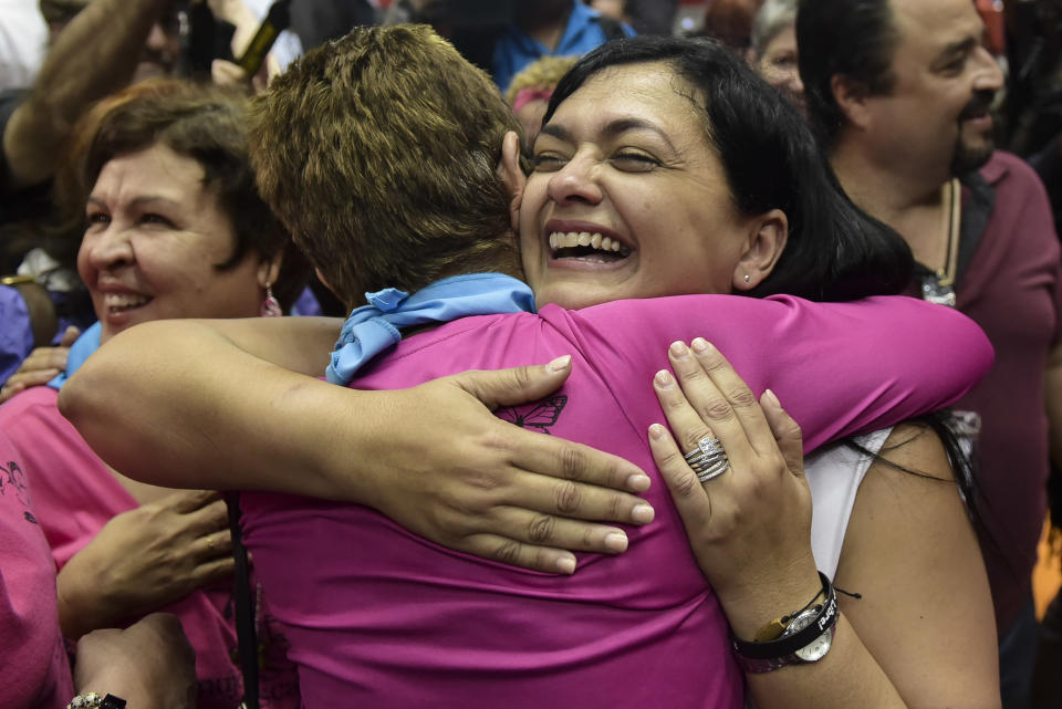 In this Jan. 18, 2017 photo, Clarisa Lopez, daughter of Puerto Rican nationalist Oscar Lopez Rivera, embraces a well wisher one day after President Barack Obama commuted her father's sentence, at a press conference at the Roberto Clemente Coliseum in San Juan, Puerto Rico. Lopez Rivera, member of the Fuerzas Armadas de Liberación Nacional, a group dedicated to the fight for the independence of Puerto Rico during the 1970s and 80s, was convicted of seditious conspiracy and weapons-related charges. (AP Photo/Carlos Giusti)