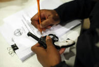 An Evanston police officer documents some information on a firearm that was turned in as part of an amnesty-based gun buyback program in Evanston, Illinois December 15, 2012. Residents were given $100 for each operational firearm given in, and no criminal charges would be laid. REUTERS/Jim Young (UNITED STATES - Tags: CRIME LAW)