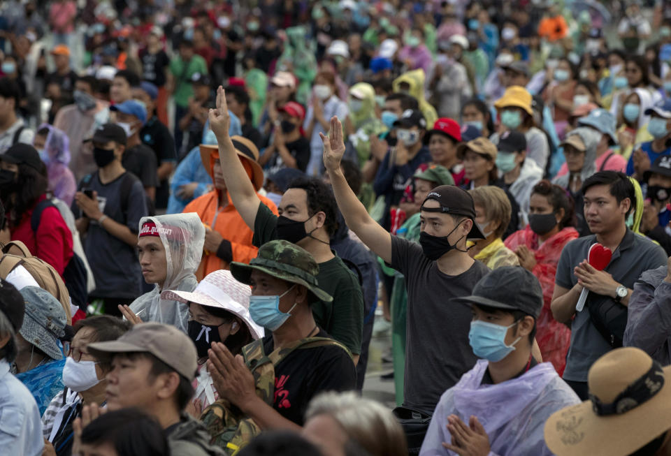 Pro-democracy protesters raise a three-fingers, symbol of resistance salute during a rally at Sanam Luang in Bangkok, Thailand, Sunday, Sept. 20, 2020. Thousands of demonstrators who occupied a historic field in Thailand's capital overnight continued with their rally on Sunday to support the demands of a student-led protest movement for new elections and reform of the monarchy. (AP Photo/Gemunu Amarasinghe)