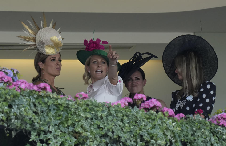 Zara Tindall, second left, gestures as she watches the third race on the third day of the Royal Ascot horserace meeting, at Ascot Racecourse, in Ascot, England, Thursday, June 16, 2022. The third day is traditionally known as Ladies Day. (AP Photo/Alastair Grant)