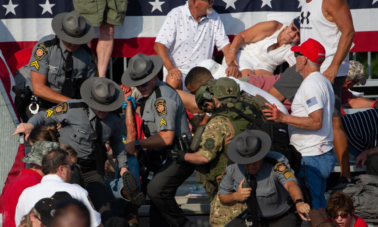 <span>A man is removed by state police from the stands after guns were fired at Donald Trump at a campaign event at Butler Farm Show Inc in Butler, Pennsylvania, on 13 July 2024.</span><span>Photograph: Rebecca Droke/AFP/Getty Images</span>