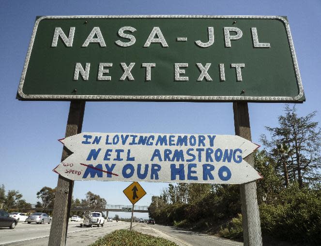 In this photo taken on Sunday, Aug. 26, 2012, a handmade sign honoring astronaut Neil Armstrong is hung under a freeway off ramp sign at the NASA-JPL exit on the CA-210 Freeway in Pasadena, Calif. Armstrong, the first man on the moon, who inspired millions with his moonwalk died Saturday, Aug. 25, 2012. He was 82. (AP Photo/Damian Dovarganes)