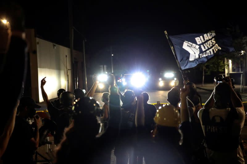 Demonstrators stand outside the Portland Police Bureau's North Precinct on the 101th consecutive night of protests against police violence and racial inequality, in Portland, Oregon