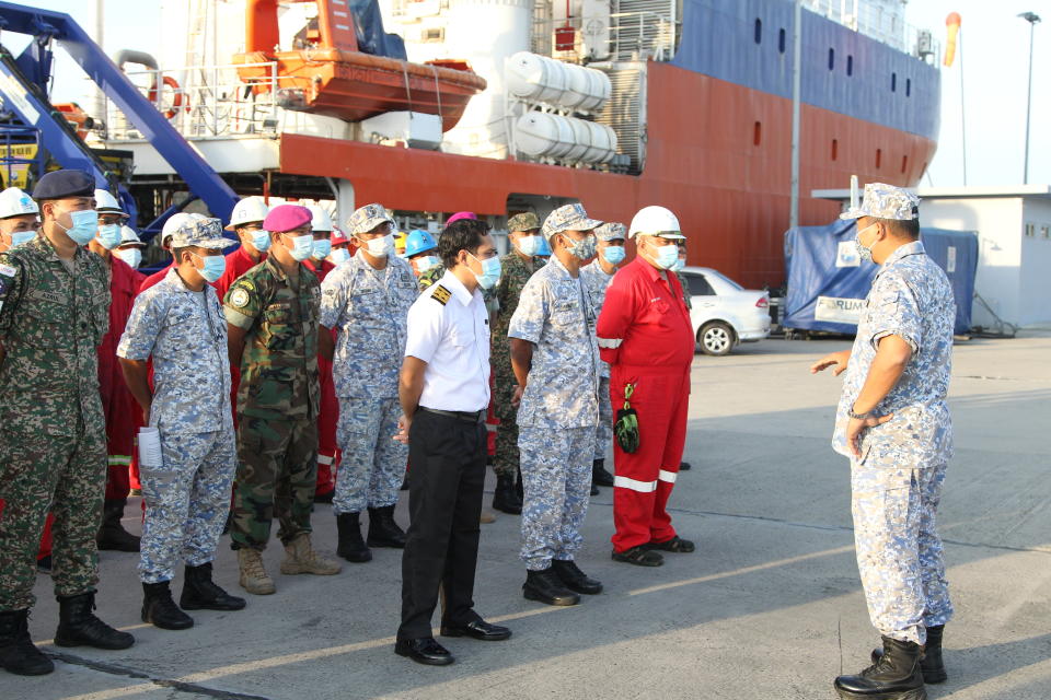 Members of the Royal Malaysian Navy and crew prepare to board a ship to join the search mission of the missing Indonesia's submarine KRI Nanggala-402, with 53 onboard, which was taking part in a torpedo drill off the island of Bali but failed to report back results of the exercise as expected, in Kota Kinabalu, Malaysia.