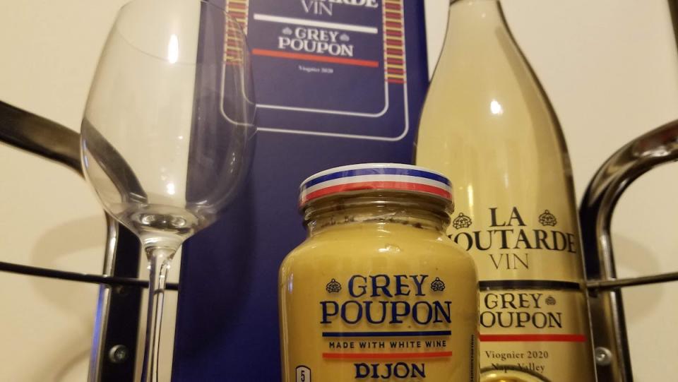 A wine glass, jar of Grey Poupon, bottle of Grey Poupon wine, and the wine box