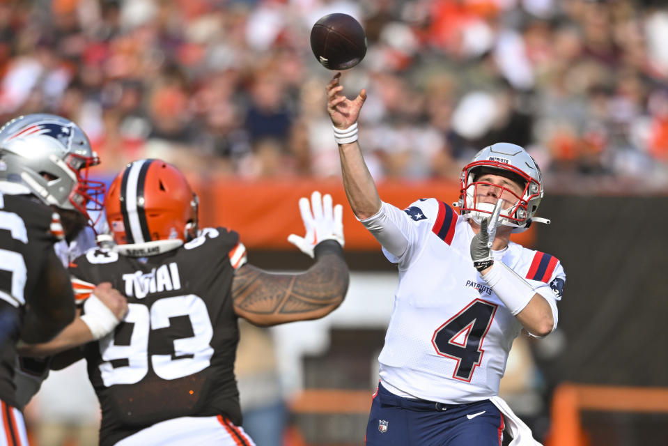 New England Patriots quarterback Bailey Zappe (4) throws a touchdown pass to tight end Hunter Henry (not shown) over Cleveland Browns defensive tackle Tommy Togiai (93) during the second half of an NFL football game, Sunday, Oct. 16, 2022, in Cleveland. (AP Photo/David Richard)