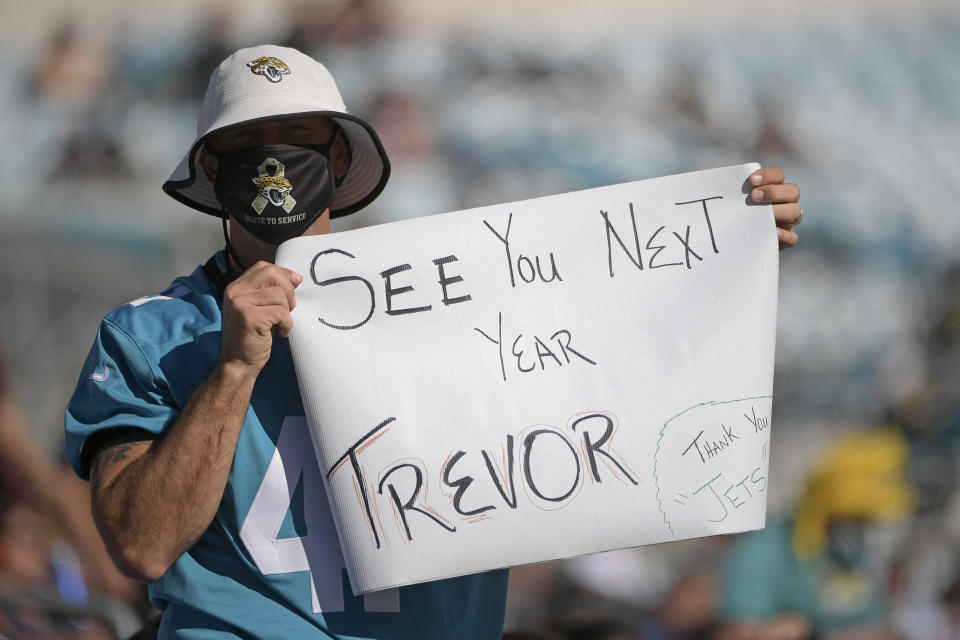 A Jacksonville Jaguars fan hold up a sign hoping that Clemson quarterback Trevor Lawerence will be the first pick for the Jacksonville Jaguars during the second half of an NFL football game against the Chicago Bears, Sunday, Dec. 27, 2020, in Jacksonville, Fla. (AP Photo/Phelan M. Ebenhack)