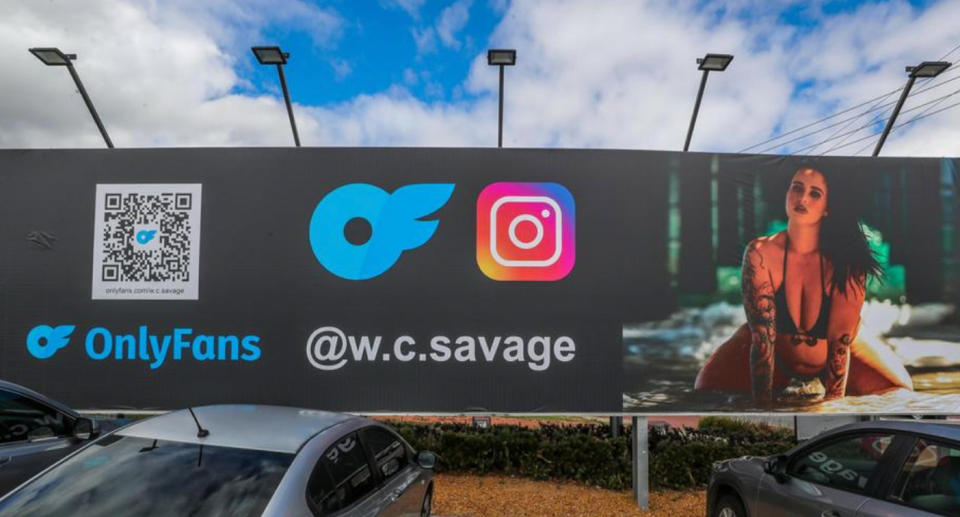 Content creator WC Savage can be seen on the righthand side of the billboard, wearing a bikini, with the QR code to her OnlyFans and instagram accounts are on the left. 