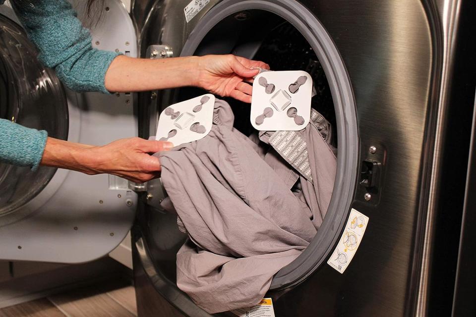 woman putting sheets in dryer with Wad-Free on the corners