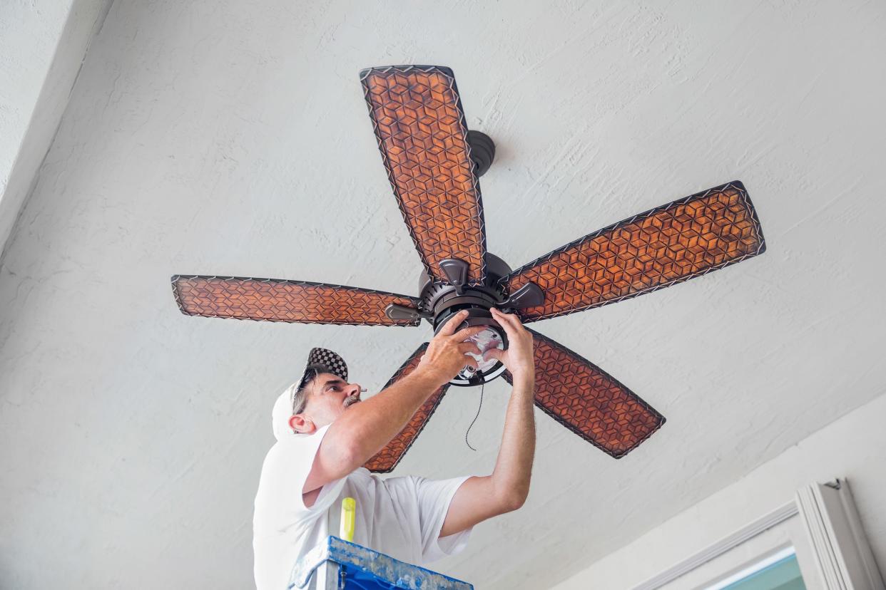 electrician hanging a ceiling fan