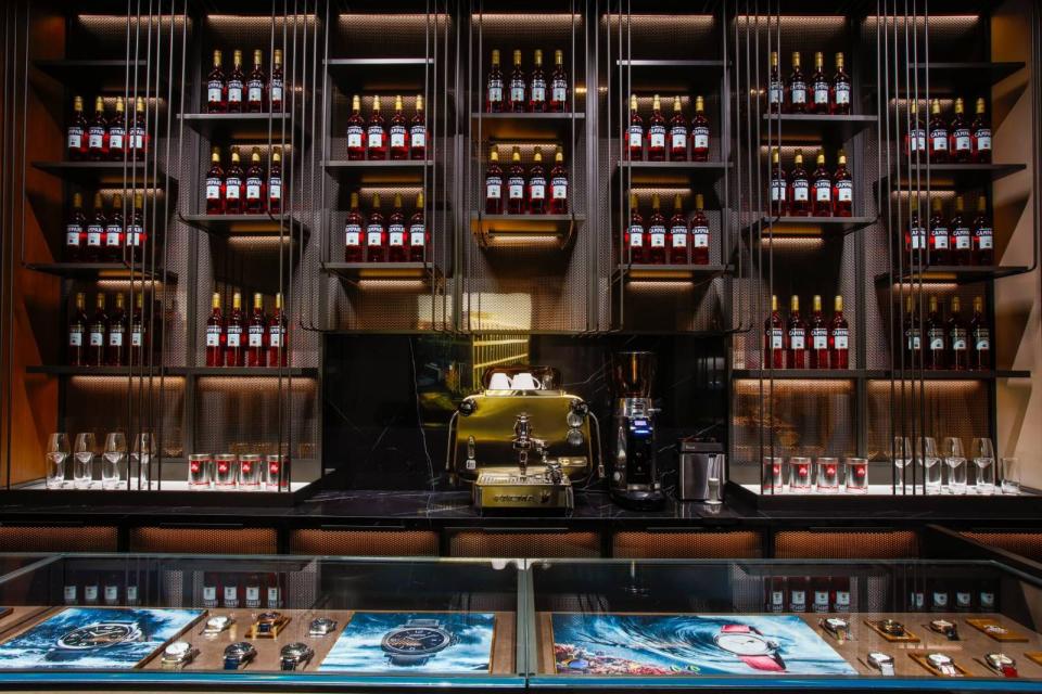 沛納海「台北101」旗艦專賣店內，佈置了一整面的紅色「CAMPARI」義大利開胃酒的酒牆，以及專業級義式濃縮咖啡機。