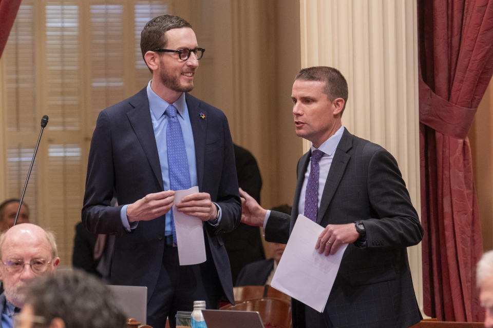 Senate President Pro Tempore Mike McGuire, right, talks to State Sen. Scott Wiener, chairman of the Senate Budget and Fiscal Review Committee, left, before Wiener presents legislation to reduce the state budget deficit at the Capitol in Sacramento, Calif., Thursday,, April 11, 2024. Republican lawmakers opposed the bill saying it only delays dealing with the budget deficit. Both houses approved the bill that takes a number of steps to reduce the state budget deficit by about $17 billion. Gov. Gavin Newsom has said the deficit is about $38 billion.(AP Photo/Rich Pedroncelli)