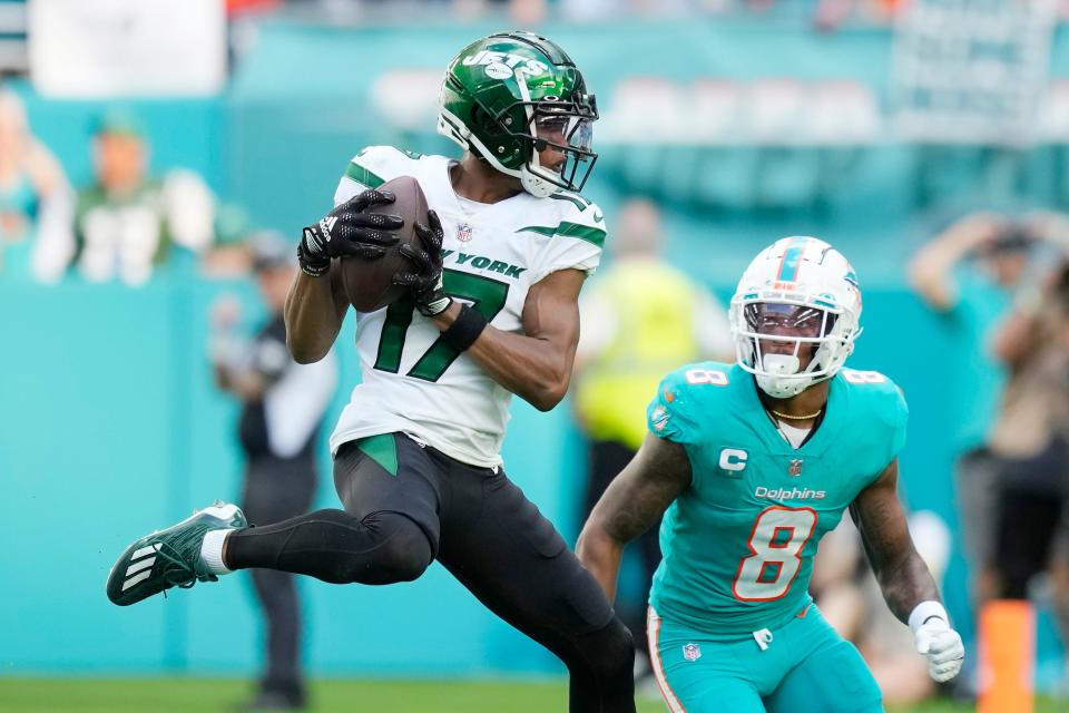 New York Jets wide receiver Garrett Wilson (17) grabs a pass in front of Miami Dolphins safety Jevon Holland (8) during the second half of an NFL football game, Sunday, Jan. 8, 2023, in Miami Gardens, Fla. (AP Photo/Rebecca Blackwell)