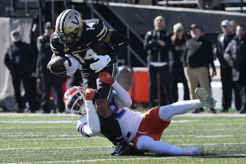 Vanderbilt wide receiver Will Sheppard (14) is brought down by Florida safety Rashad Torrence II (22) in the first half of an NCAA college football game Saturday, Nov. 19, 2022, in Nashville, Tenn. (AP Photo/Mark Humphrey)