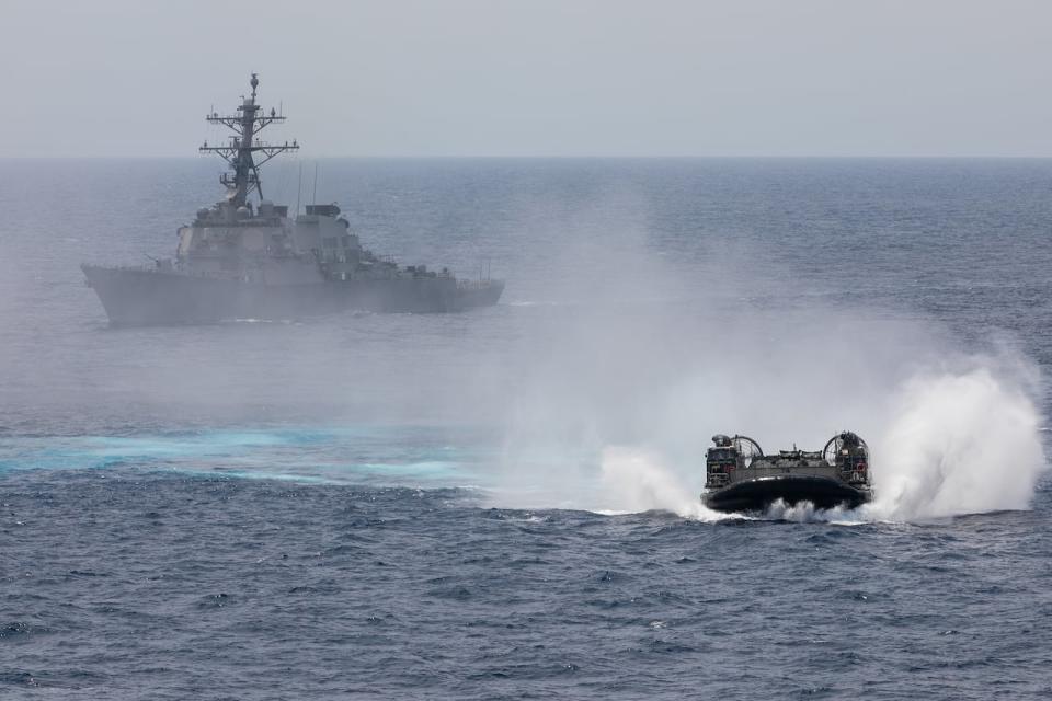 230215-N-AT895-1074 SOUTH CHINA SEA (Feb. 15, 2023) A landing craft air cushion (LCAC) from Assault Craft Unit (ACU) 5 maneuvers in front of the Arleigh Burke-class guided-missile destroyer USS Decatur (DDG 73). Nimitz Carrier Strike Group (NIMCSG) and Makin Island Amphibious Ready Group (MKI ARG), with embarked 13th Marine Expeditionary Unit (MEU), are conducting combined expeditionary strike force (ESF) operations, demonstrating unique high-end war fighting capability, maritime superiority, power projection and readiness. Operations include integrated training designed to advance interoperability between the two groups while simultaneously demonstrating the U.S. commitment to our alliances and partnerships in the Indo-Pacific region. NIMCSG is in U.S. 7th Fleet conducting routine operations. 7th Fleet is the U.S. Navy's largest forward-deployed numbered fleet, and routinely interacts and operates with Allies and partners in preserving a free and open Indo-Pacific region.  (U.S. Navy photo by Mass Communication Specialist 1st Class Nathan Laird)