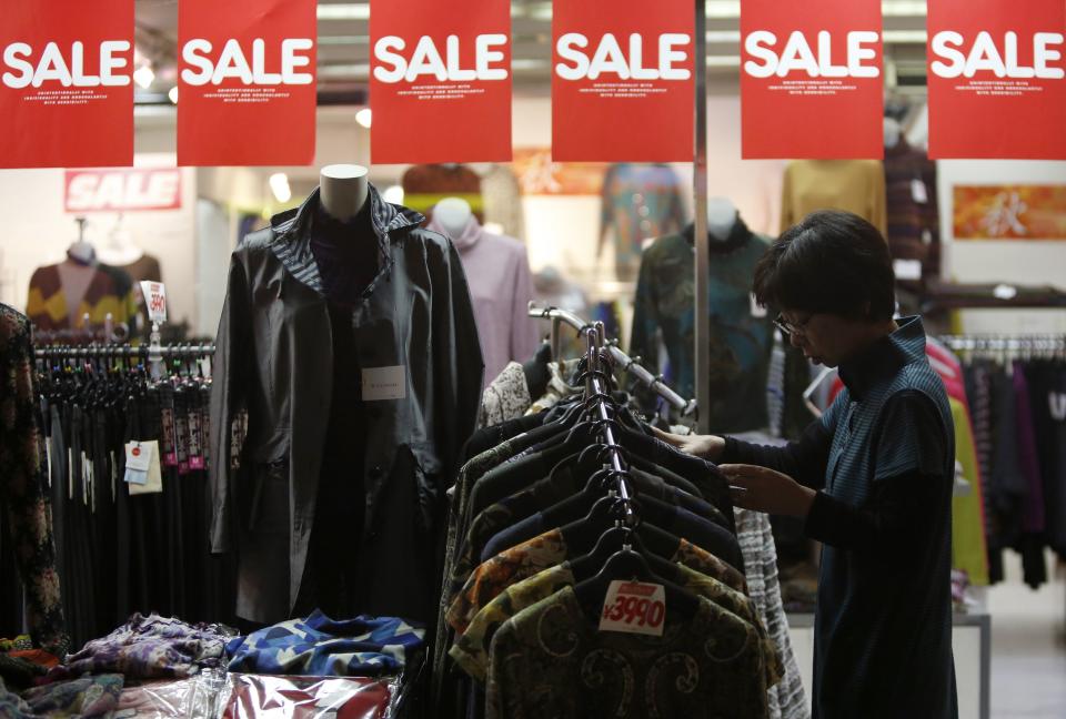 A woman looks at items in a clothing store at a shopping district in Tokyo October 24, 2013. Japan's core consumer prices rose 0.7 percent in September from a year earlier, staying near the fastest growth in almost five years, government data showed on Friday, in a sign that the economy is heading towards the end of deflation. Picture taken October 24, 2013. REUTERS/Yuya Shino (JAPAN - Tags: BUSINESS)