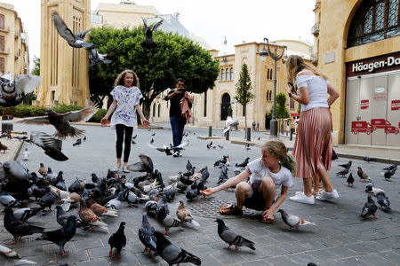 Girls play with pigeons near the parliament building in downtown Beirut, Lebanon April 12, 2017. REUTERS/Mohamed Azakir