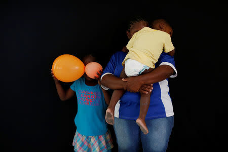 A woman from Honduras who didn't want to be identified and who is hoping to get refugee status in Mexico, poses for a photograph with her children at a migrant shelter, known as The 72, in Tenosique, Tabasco, Mexico, April 12, 2017. "I left Honduras because of violence and extortion from gang members," she said. REUTERS/Carlos Jasso