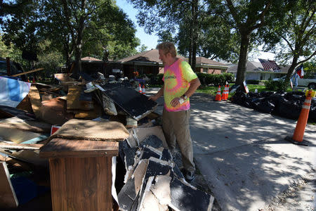 Mike McCorkle examines a pile of debris he and a friend have hauled out of his house which was flooded by the catastrophic rains brought by Hurricane Harvey late last month in Bellaire, Texas, U.S., September 8, 2017. REUTERS/Nick Carey
