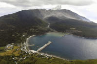 A smoke column from Shindake volcano is seen after its eruption in Kuchinoerabu island, southern Japan, Thursday, Jan. 17, 2019. Japan Meteorological Agency said Thursday's eruption caused volcanic rocks flying out of the crater and pyroclastic flows pouring down but have not reached as far as the residential area 2 kilometers (1.2 mile) away. (Kyodo News via AP)