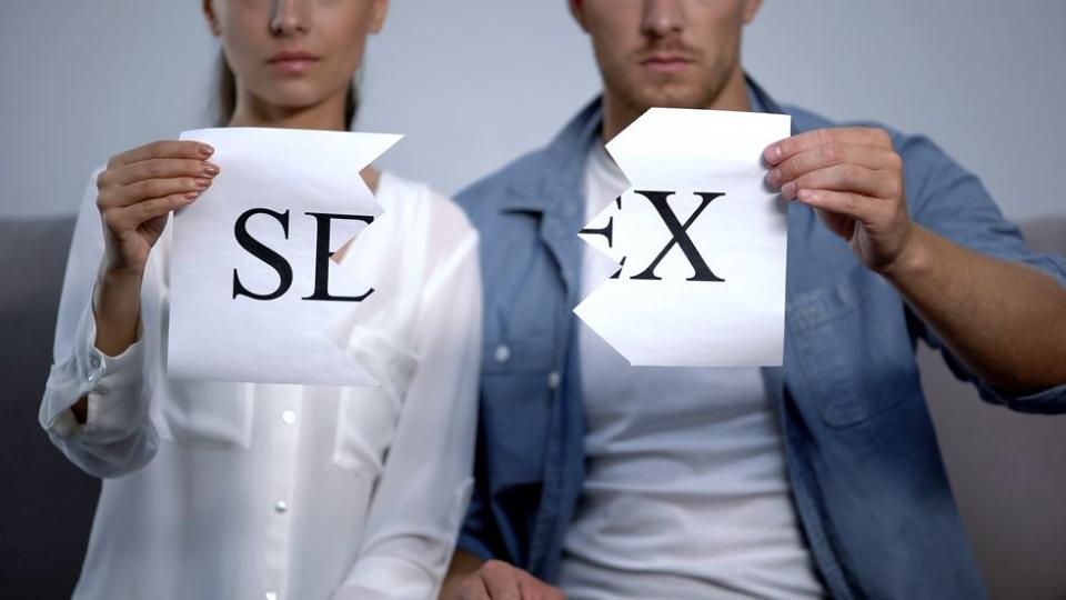 couple ripping up a sex sign