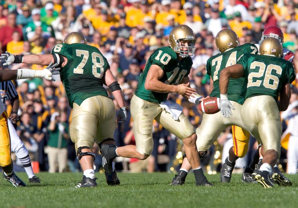 Former Notre Dame quarterback Brady Quinn (10) handing off to halfback Travis Thomas (26) during a 2005 game against USC