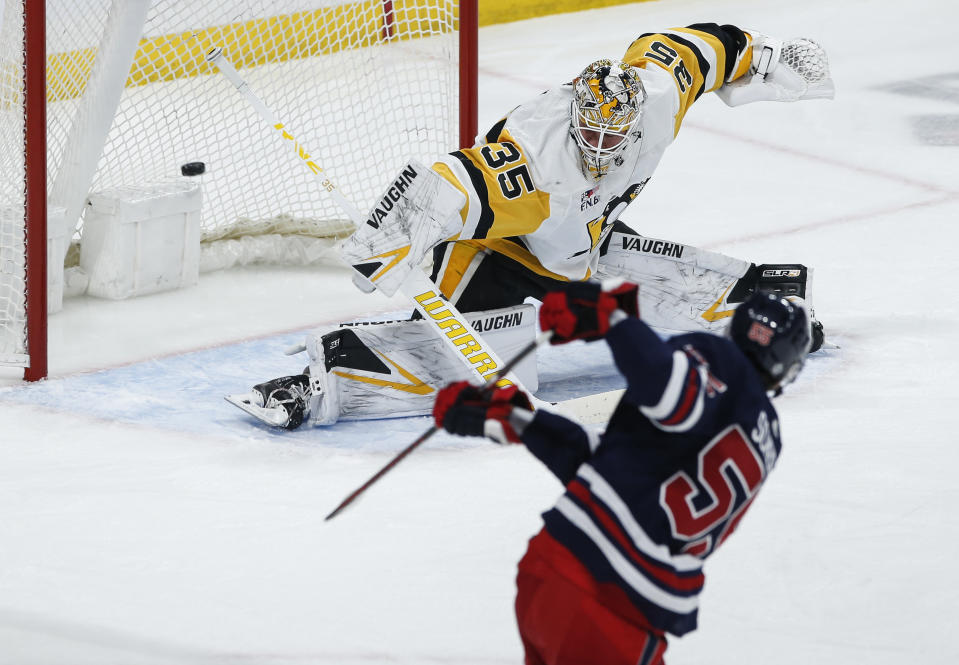 Winnipeg Jets' Mark Scheifele (55) scores on Pittsburgh Penguins goaltender Tristan Jarry (35) during the first period of an NHL hockey game Saturday, Feb. 10, 2024, in Winnipeg, Manitoba. (John Woods/The Canadian Press via AP)