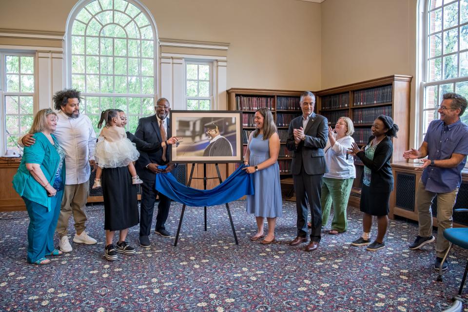 Family and Drake University faculty members honor Wayne Ford, former state legislator and founder of the nonprofit social services agency Urban Dreams, with the unveiling of his official portrait on May 19, 2022. From left are Ford's former wife, Linda Ford; their son, Ryan Ford; his wife, Renee Airo-Ford, and their daughter, Faven Ford; Wayne Ford; Hope Bibens, director of the university's archives and special collections; Drake University President Marty Martin; and other Drake staff.