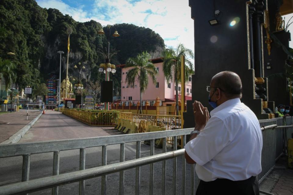 A Hindu devotee prays at the entrance of the Sri Subramanian Swamy Temple at Batu Caves during Thaipusam January 28, 2021. — Picture by Yusof Mat Isa