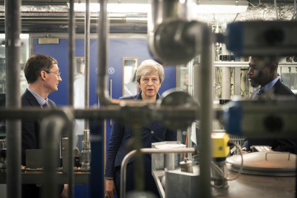 Britain's Prime Minister Theresa May during a visit to Imperial College where she saw machinery which converts carbon dioxide into oxygen, in London, Wednesday, June 12, 2019. Britain's outgoing prime minister on Wednesday announced plans to eliminate the country's net contribution to climate change by 2050 as Europe's effort to slow global warming picked up speed. (Stefan Rousseau/Pool photo via AP)