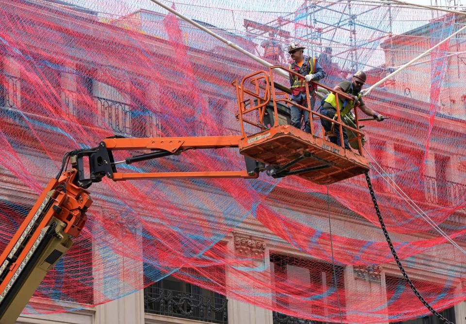 Traffic was blocked Saturday at the intersection of North High and Gay streets in downtown Columbus for the day-long installation of "Current," a nylon sculpture by Janet Echelman. Made of 78 miles of red and blue twine and more than 500,000 knots, the sculpture is 229 feet long and hangs 35 to 126 feet off the ground. It is the largest piece of public art in Columbus.