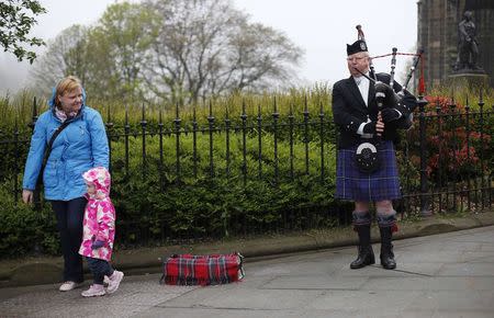 A busker plays the bagpipes on Princes Street, the main shopping street in Edinburgh, Scotland April 30, 2014. REUTERS/Suzanne Plunkett