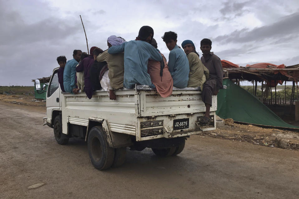 Local residents travel in a vehicle as they evacuate due to Cyclone Biparjoy approaching, at a costal area Keti Bandar near Thatta, in Pakistan's Sindh province, Tuesday, June 13, 2023. Pakistan's army and civil authorities are planning to evacuate 80,000 people to safety along the country's southern coast, and thousands in neighboring India sought shelter ahead of Cyclone Biparjoy, officials said. (AP Photo/Muhammad Hamza)