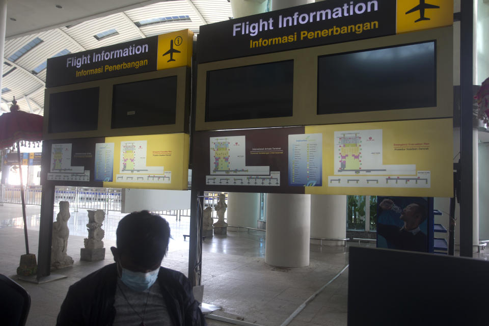 Flight information screens are blank at International Ngurah Rai Airport before its reopening in Bali, Indonesia, Thursday, Oct. 14, 2021. The Indonesian resort island of Bali welcomed international travelers to its shops and white-sand beaches for the first time in more than a year Thursday - if they're vaccinated, test negative, hail from certain countries, quarantine and heed restrictions in public. (AP Photo/Firdia Lisnawati)